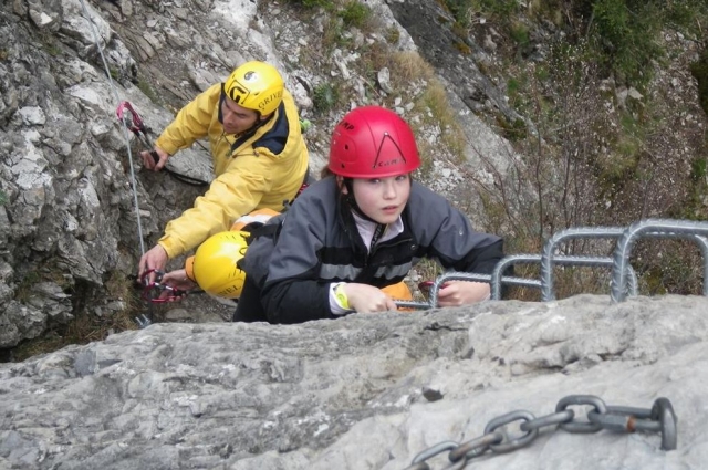  une fille et un homme escaladant un rocher 